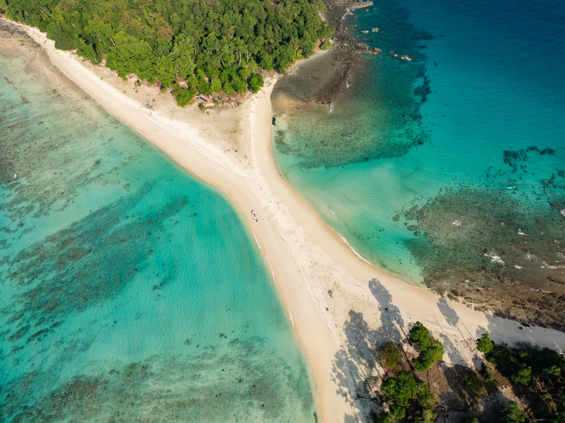 Breathtaking aerial view of Cinque Island with vibrant turquoise waters and lush greenery in the Andaman and Nicobar Islands.