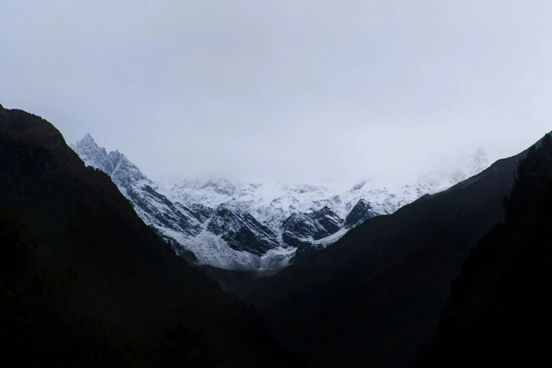 Stunning view of snow-capped mountains at Kedarnath, India under an overcast sky.