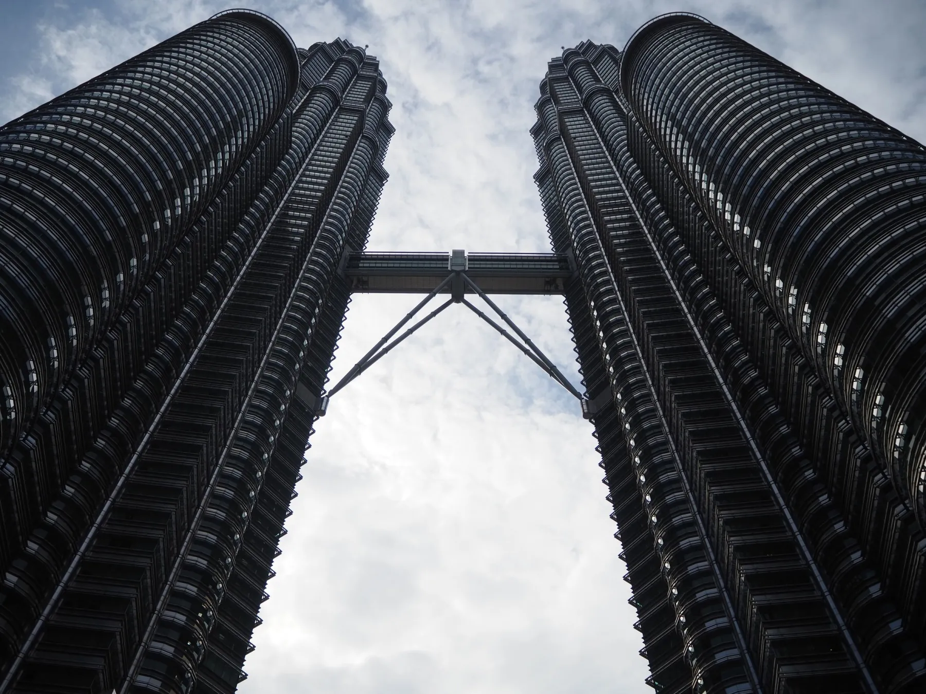 Dramatic low angle shot of the iconic Petronas Twin Towers in Kuala Lumpur.