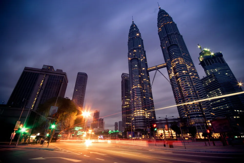 Beautiful long exposure of Kuala Lumpur at night showcasing iconic Petronas Towers and urban lights.