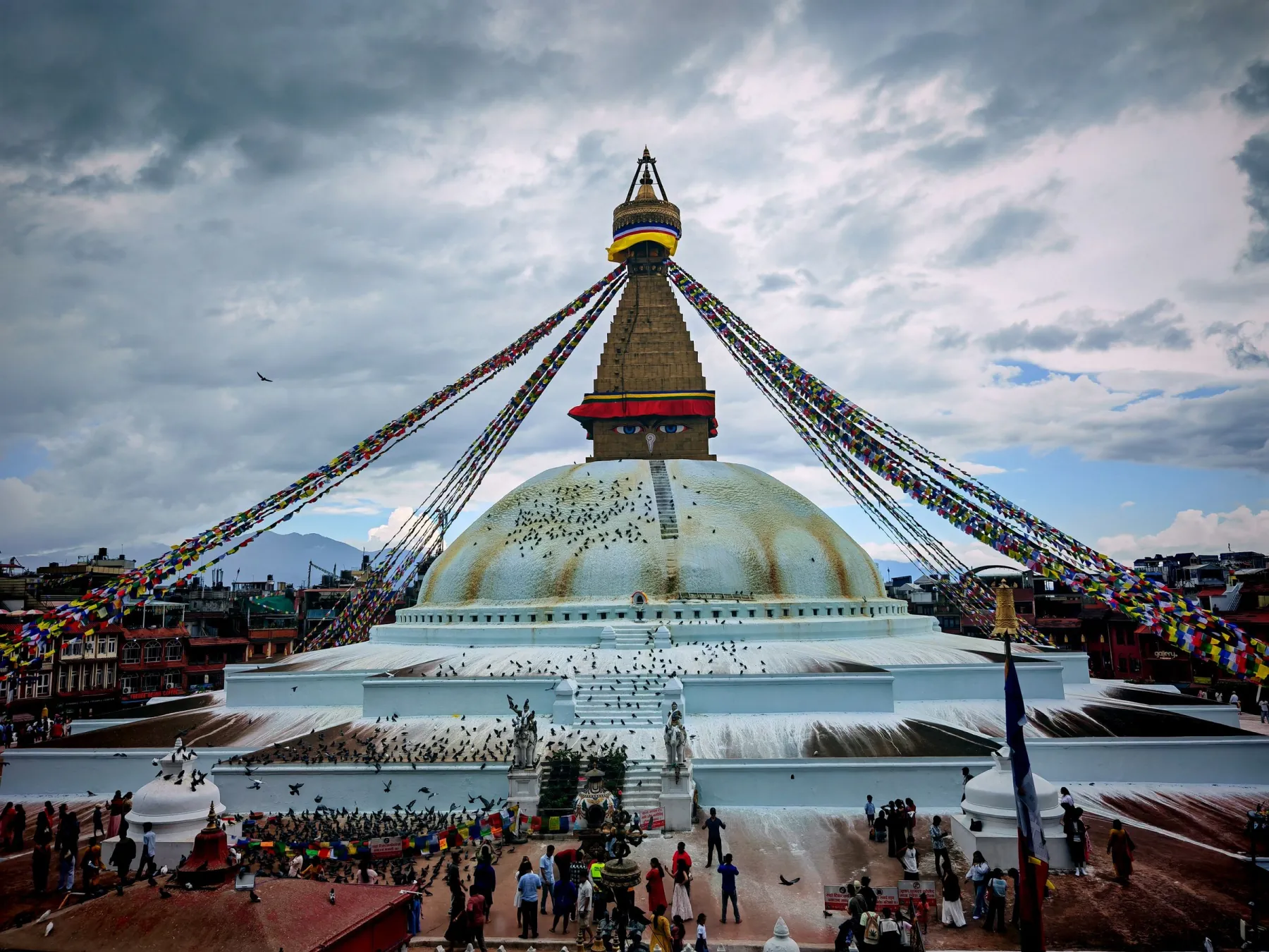 A vibrant scene capturing Boudhanath Stupa adorned with colorful prayer flags in Kathmandu, Nepal.
