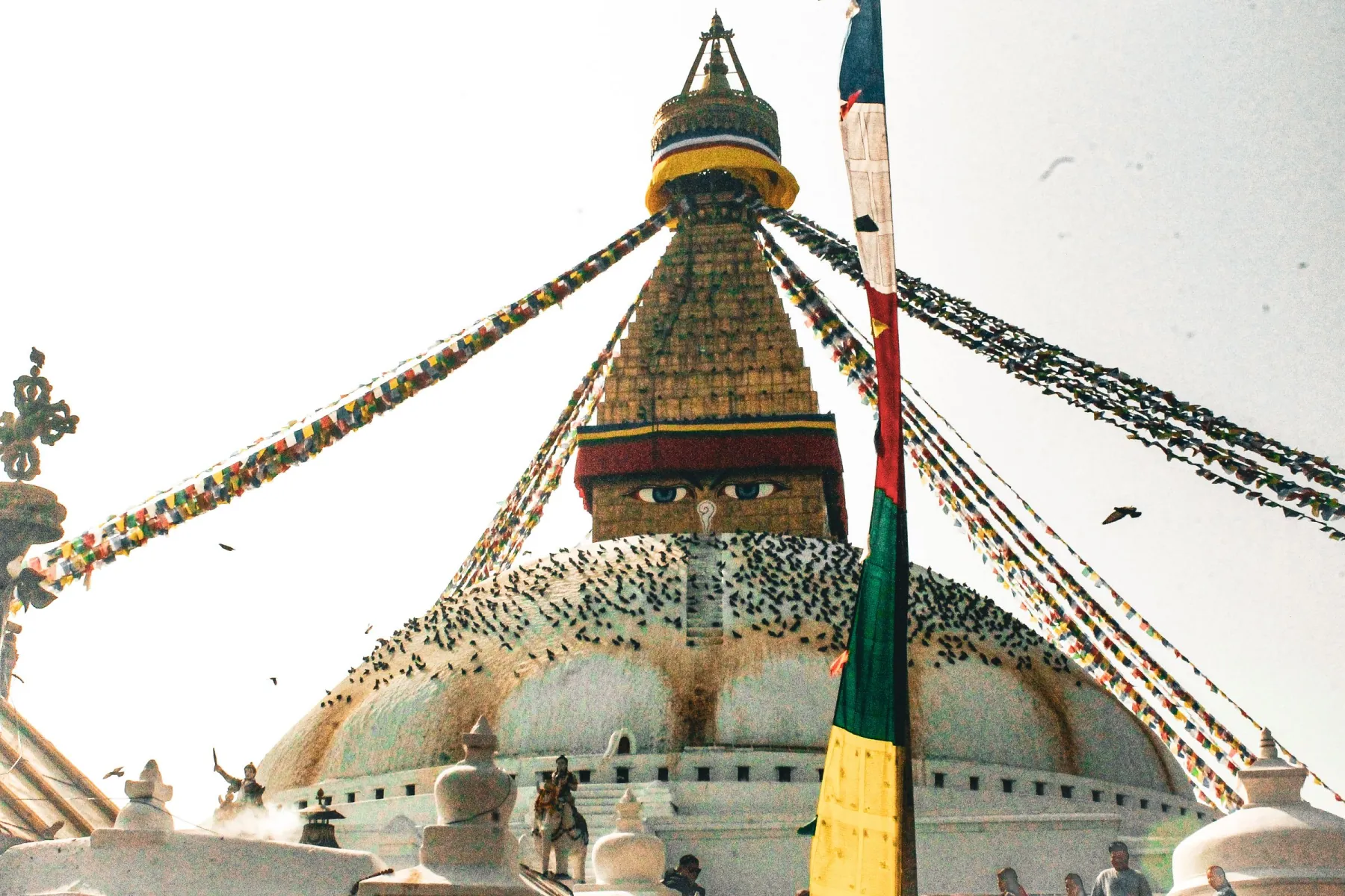 Boudhanath Stupa with colorful prayer flags under clear sky in Kathmandu, Nepal.